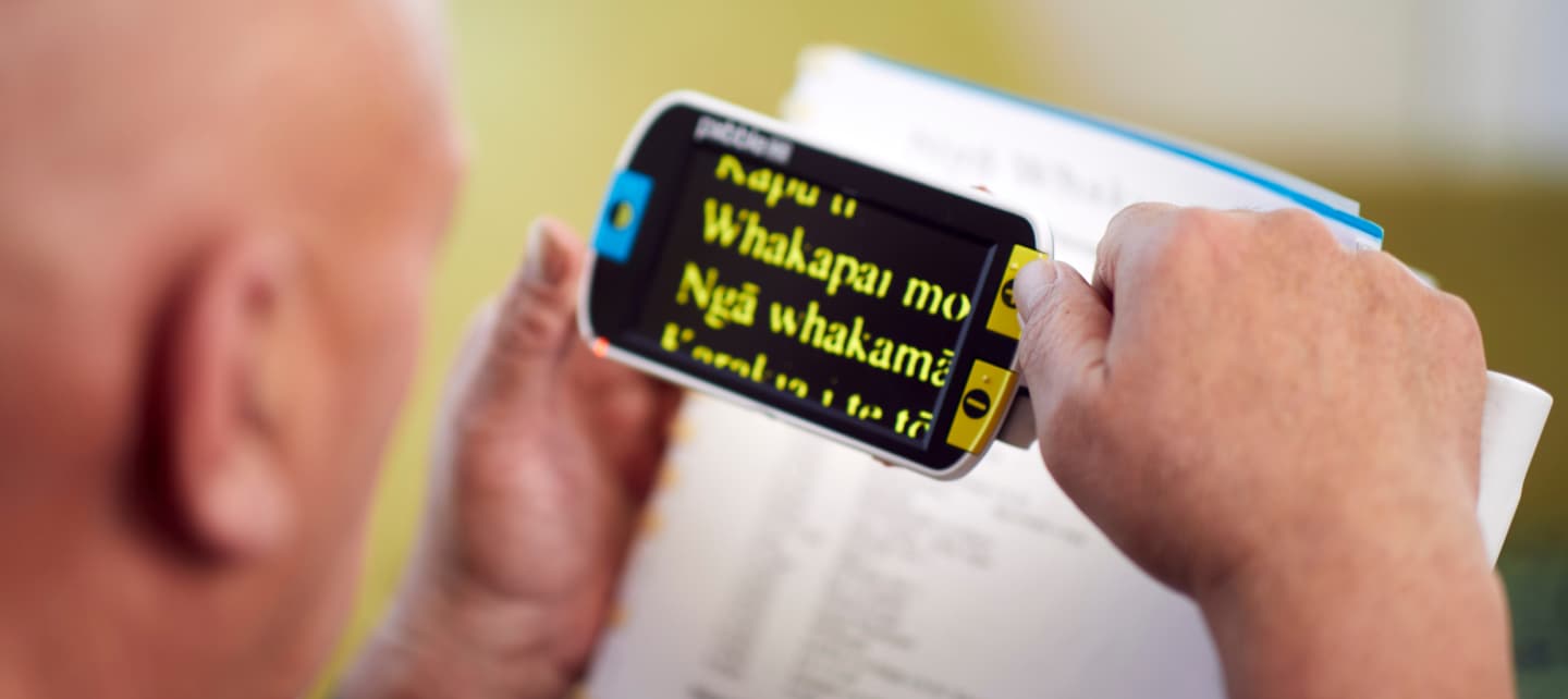 Client Jackson is using his magnifier to read in te reo