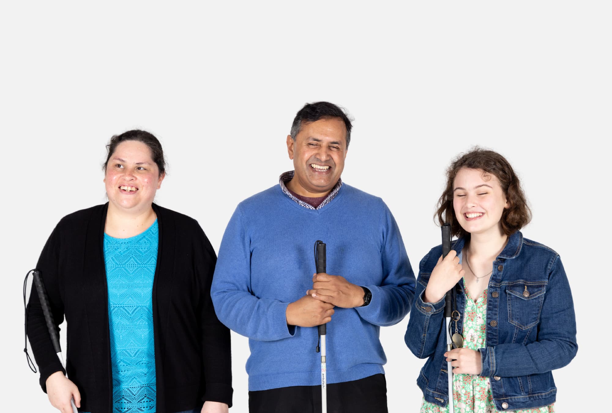 Clients Chantelle, David and Imogen stand together holding their canes and looking happy