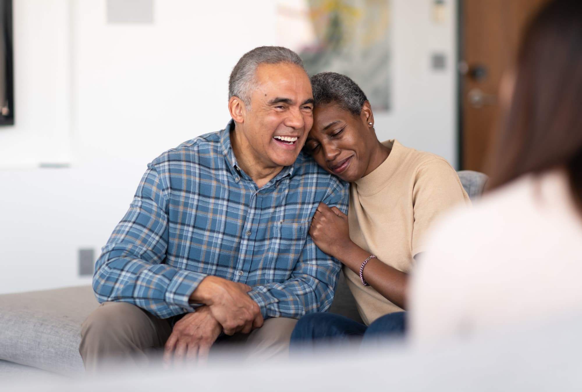 Couple smiling while sitting on a couch