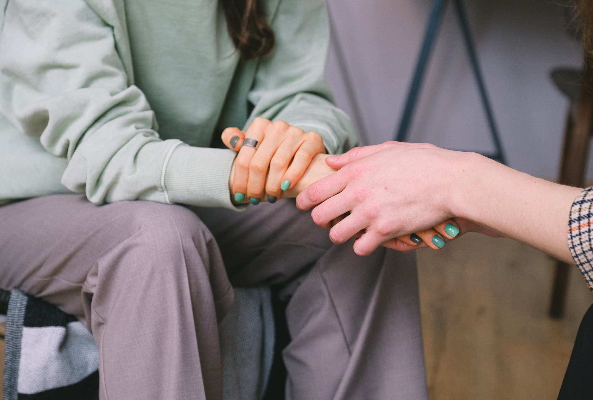 A close up image of a person holding another persons hand