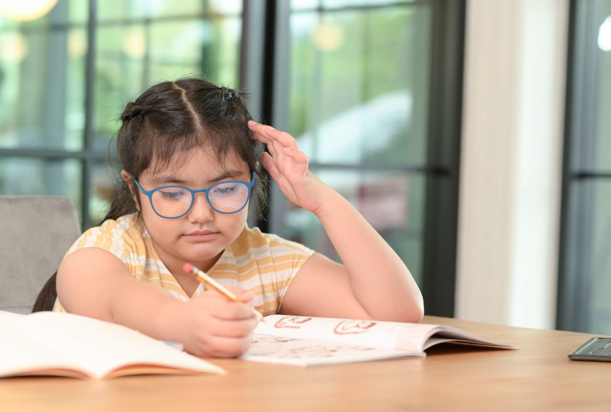 A young child studying on a table