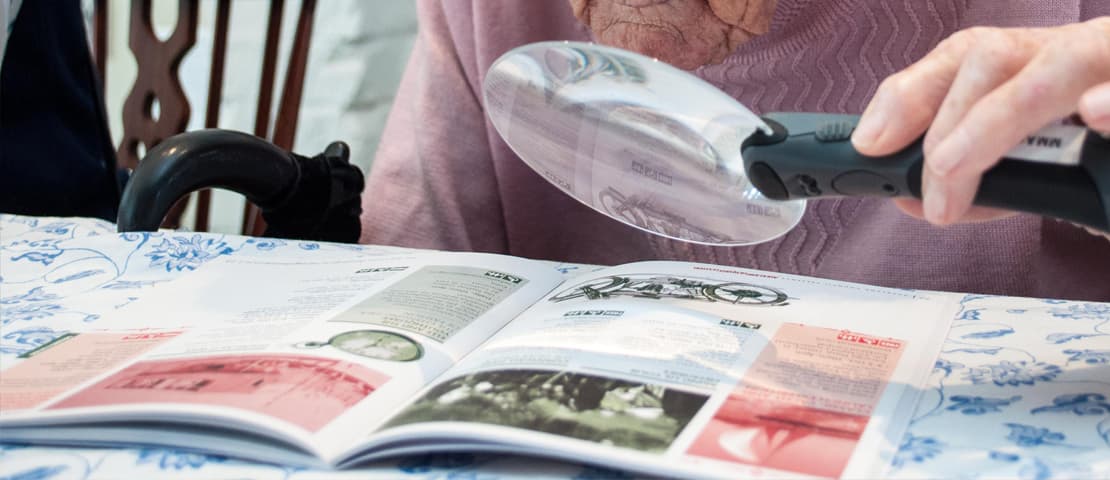 A client reading using a hand magnifier