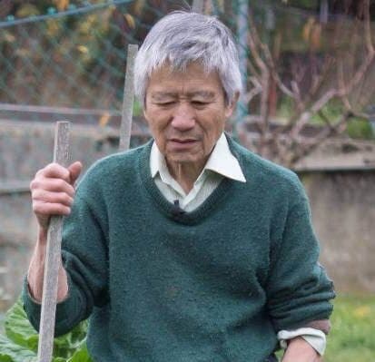 Roger Is standing in his garden looking at the camera