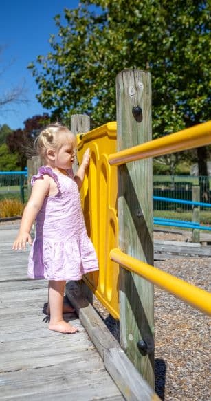 Mickayla playing on a playground on a sunny day.