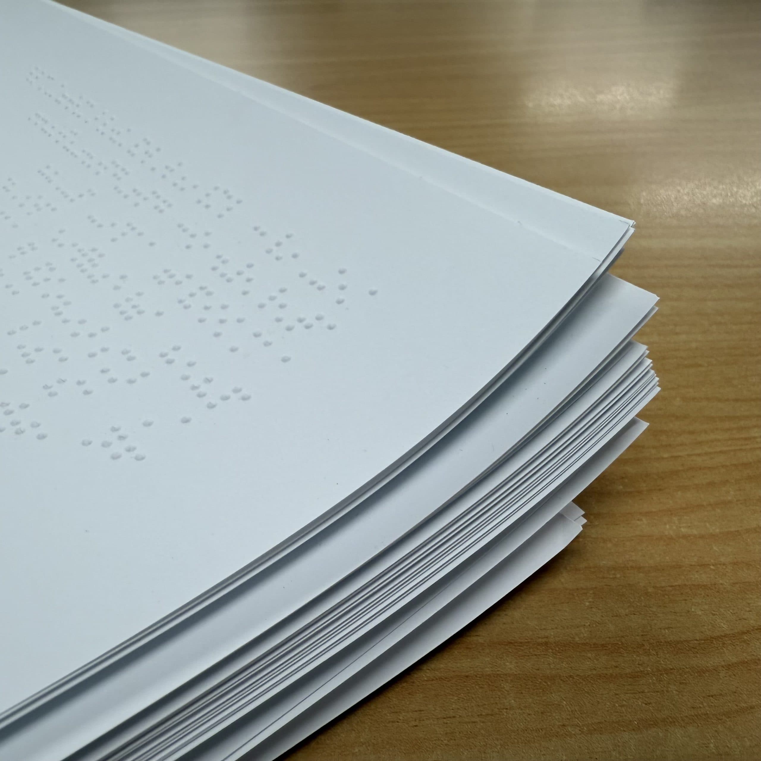 Stacks of white pages of Braille text.