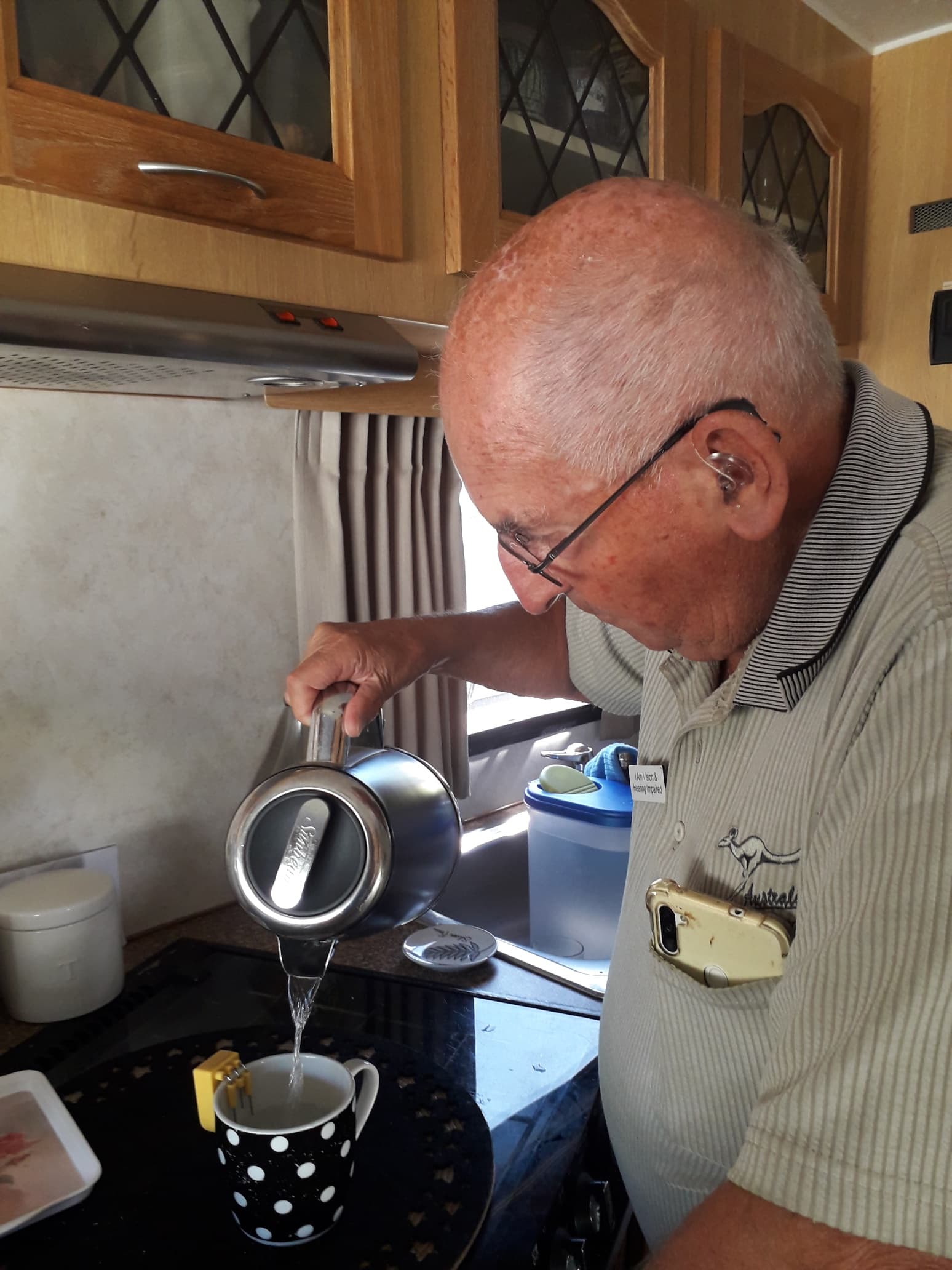 A man pouring a cup of tea with the aid of a liquid level indicator.