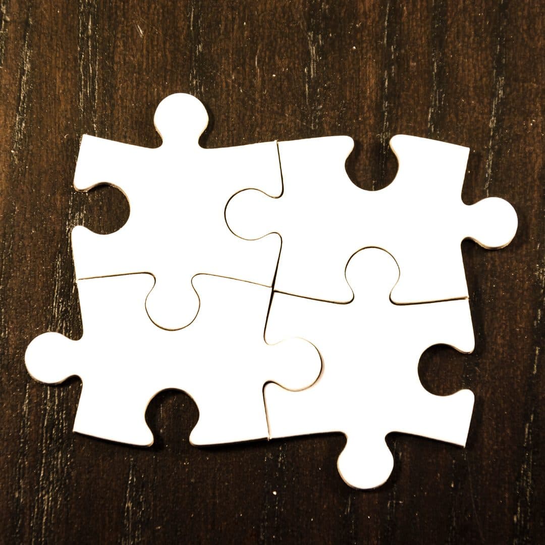 Four blank white jigsaw puzzle pieces joined in a square.