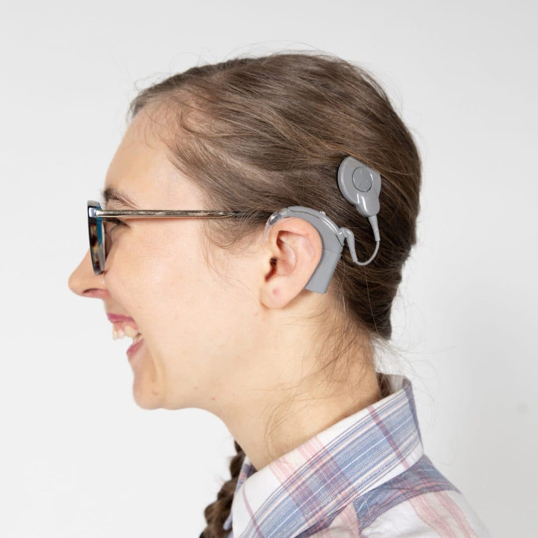 Deafblind client Savanagh faces the left hand side and showing her cochlear implant.
