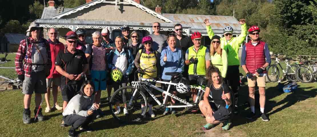 A group of clients and volunteers with their bikes who are doing the Otago Trail