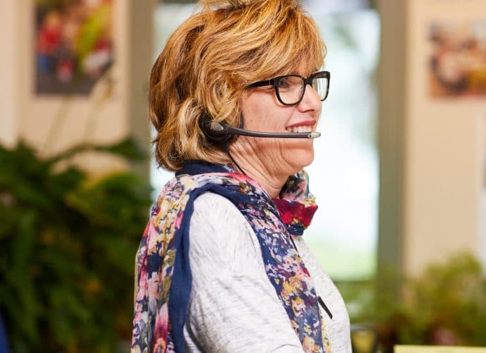 A female staff member in the Blind Low Vision NZ contact centre is responding to a call