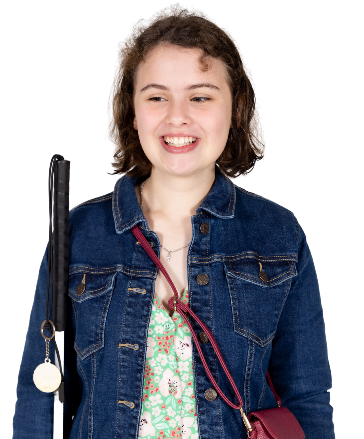 Client Isabelle is holding her white cane and smiling confidently at the camera