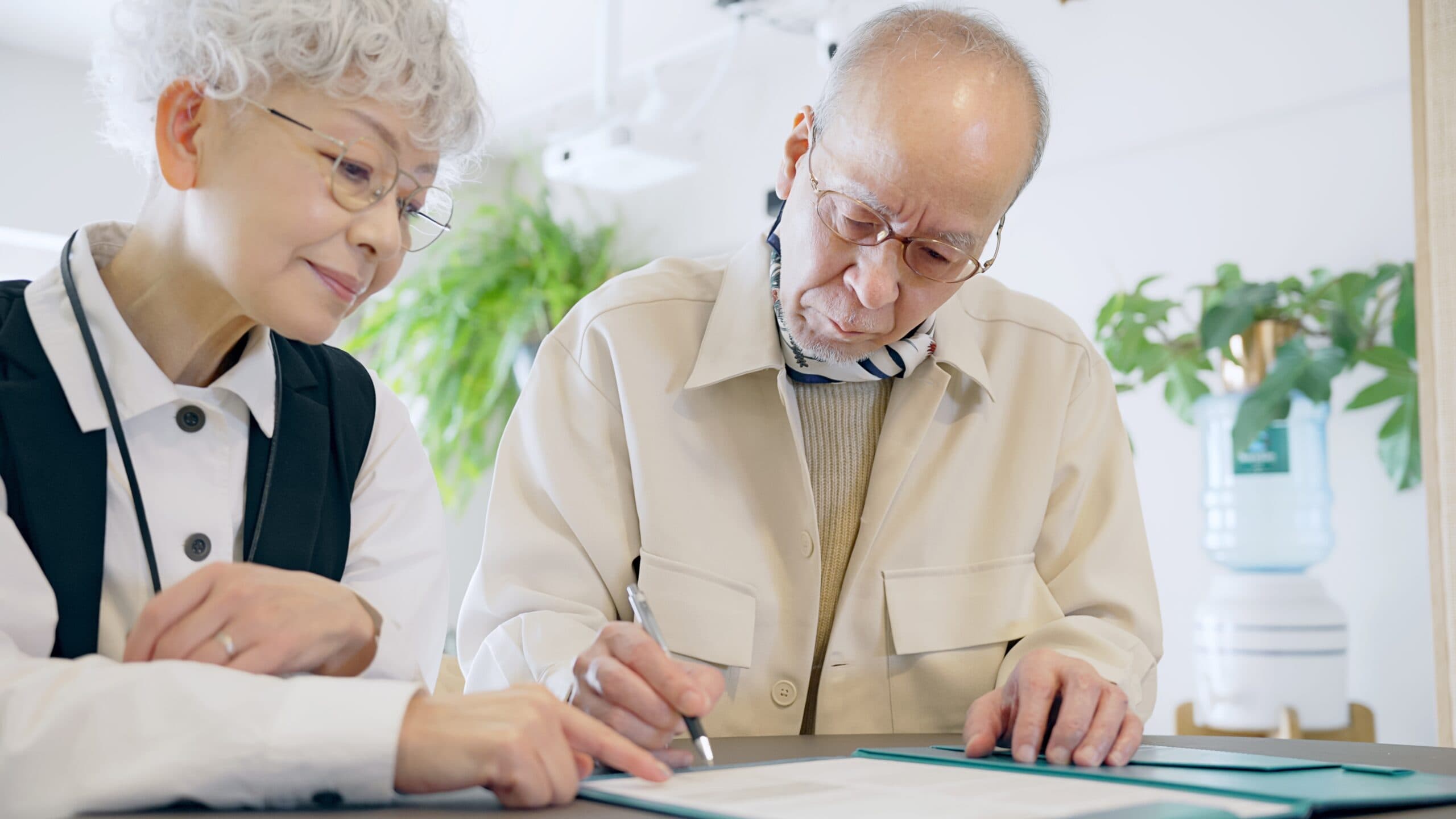 An elderly couple completing some forms