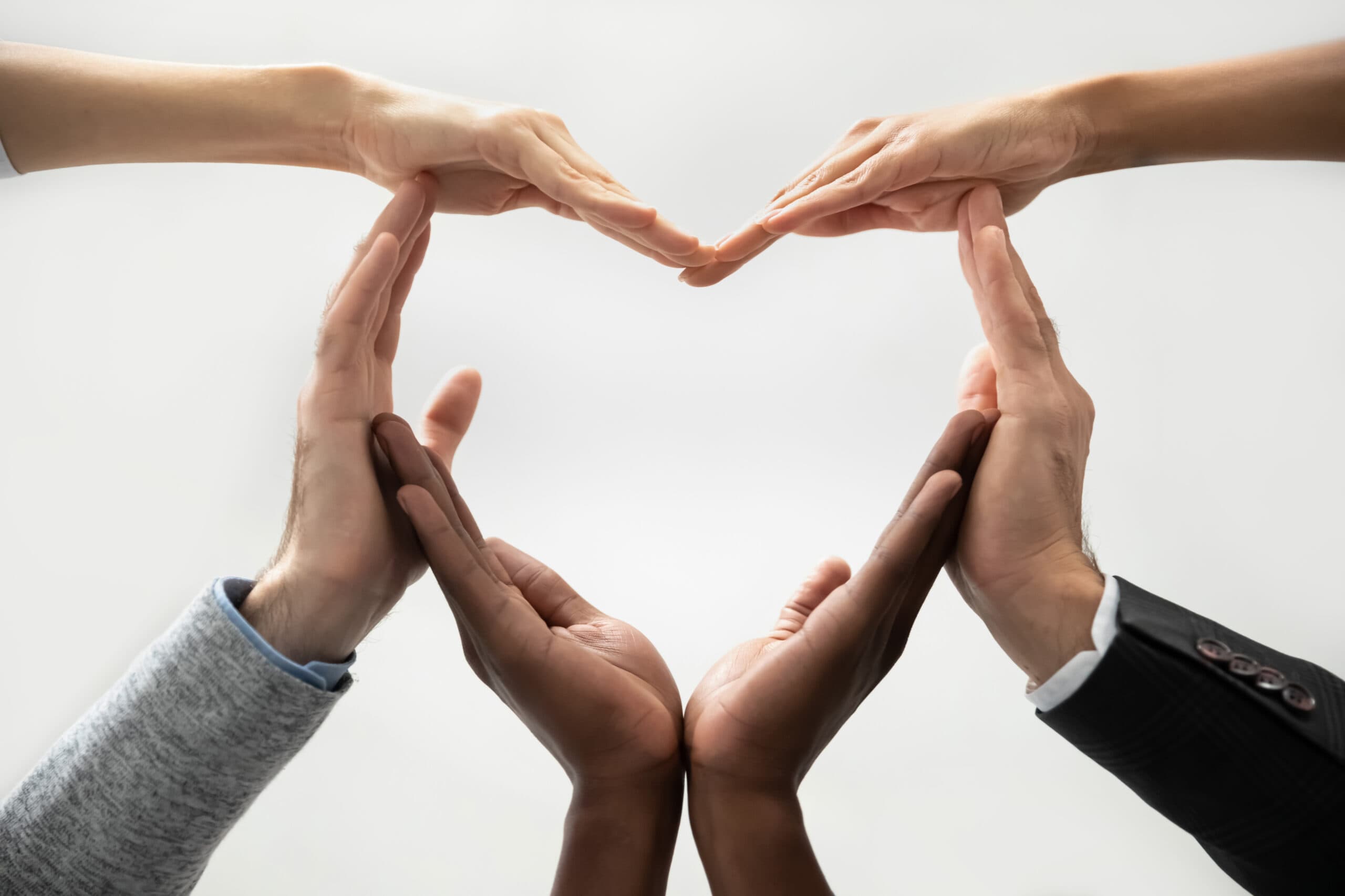 A group of hands forming a heart shape