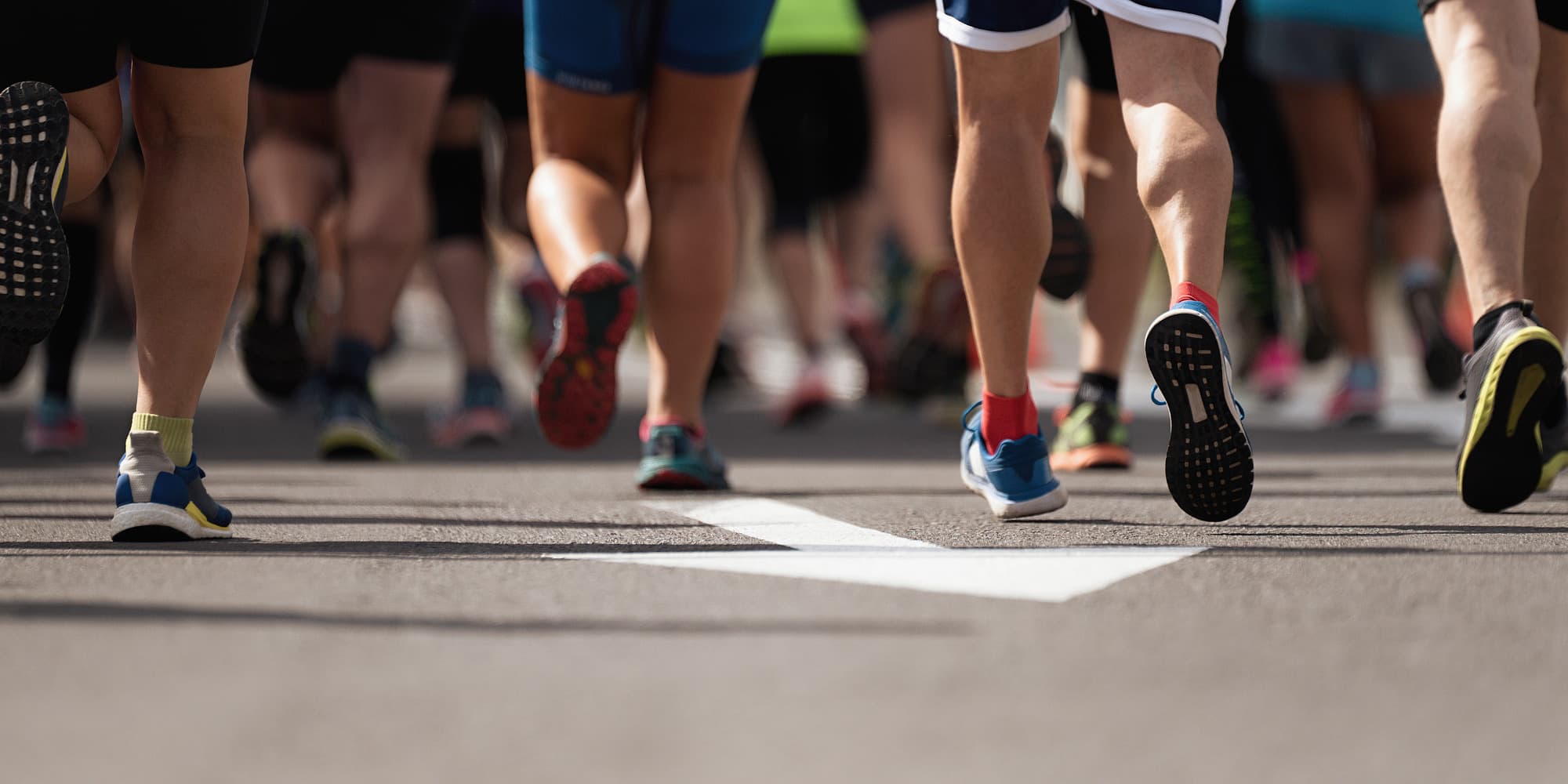Dozens of legs pound the pavement during a fun run