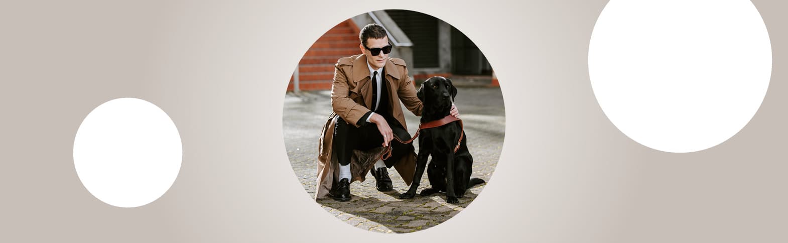 On a grey background is a circular image of Michael crouched with his black Labrador retriever guide dog, Taine.