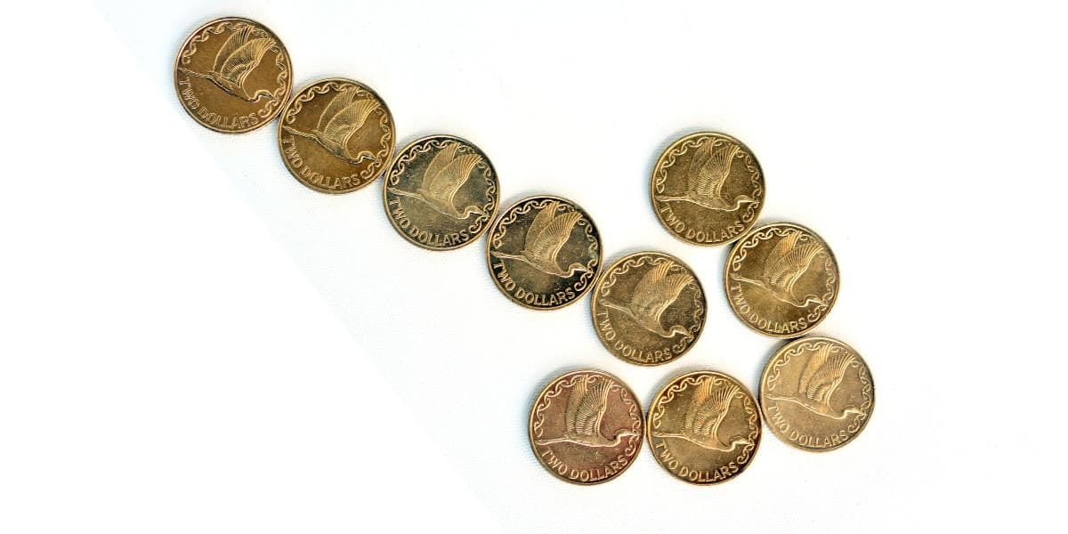 Ten Two Dollar New Zealand coins grouped together to form a downward pointing arrow.
