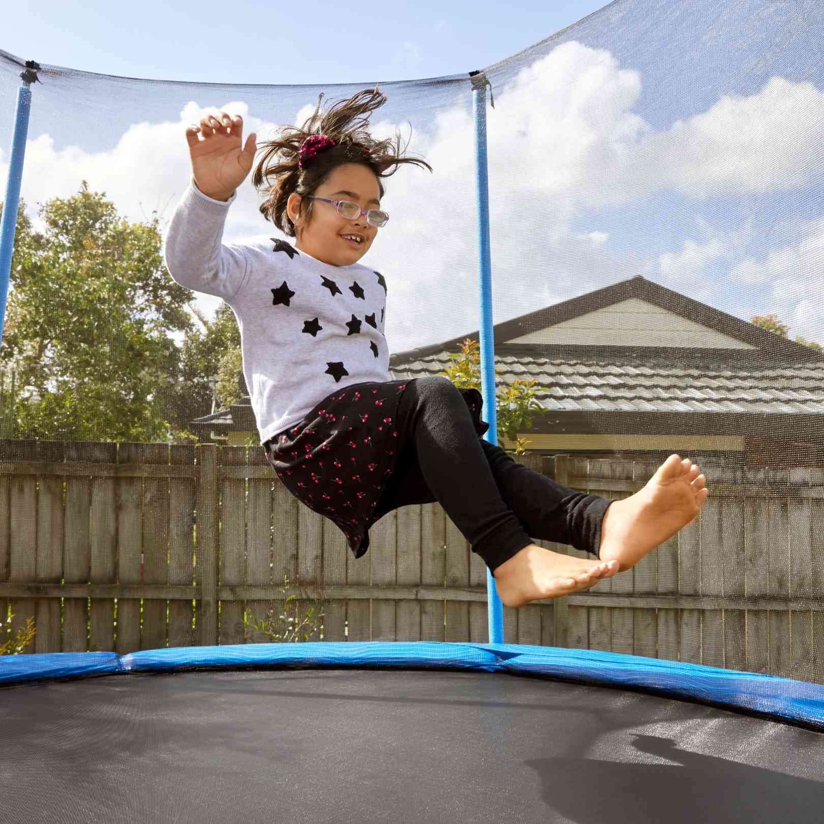 A blind child bouncing on a trampoline